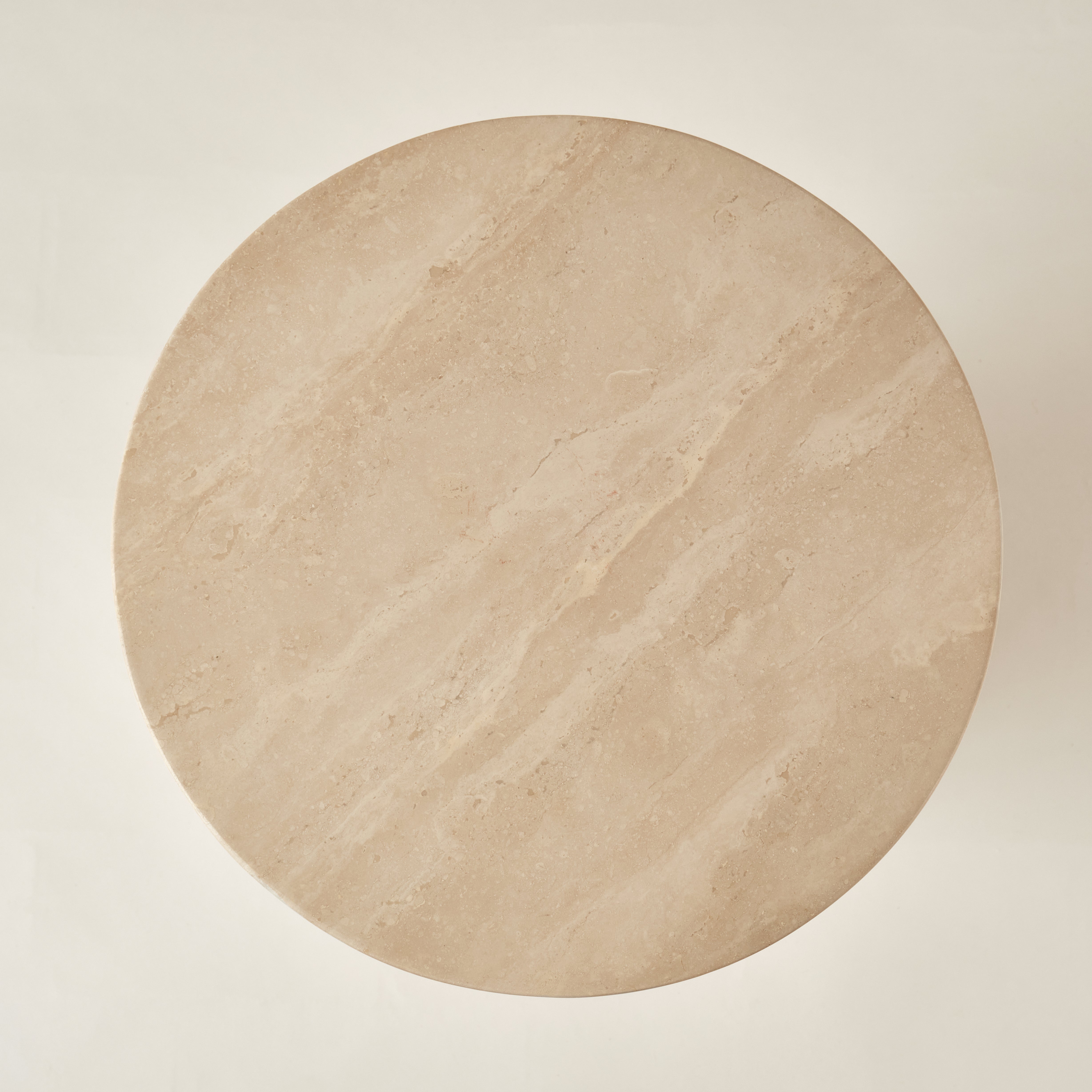Draufsicht auf die runde Tischplatte eines Beistelltisches aus Travertin, die die feine Maserung und natürliche Textur des hochwertigen Steins hervorhebt. Perfekt für moderne und minimalistische Einrichtungsstile.