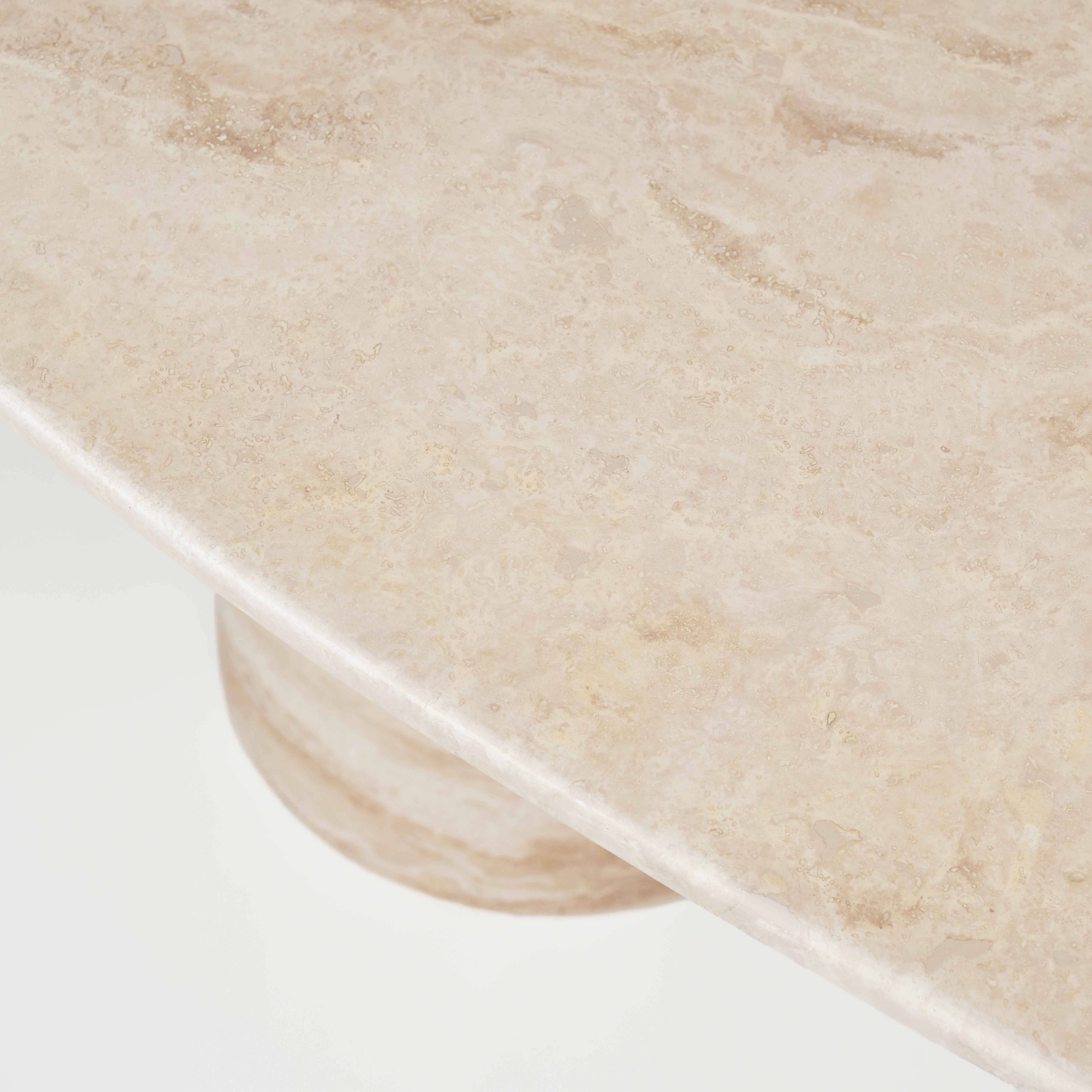 Nahaufnahme der Tischplatte des Esstisches Mika aus hochwertigem Travertin, die die natürliche Struktur und Textur des Materials betont.