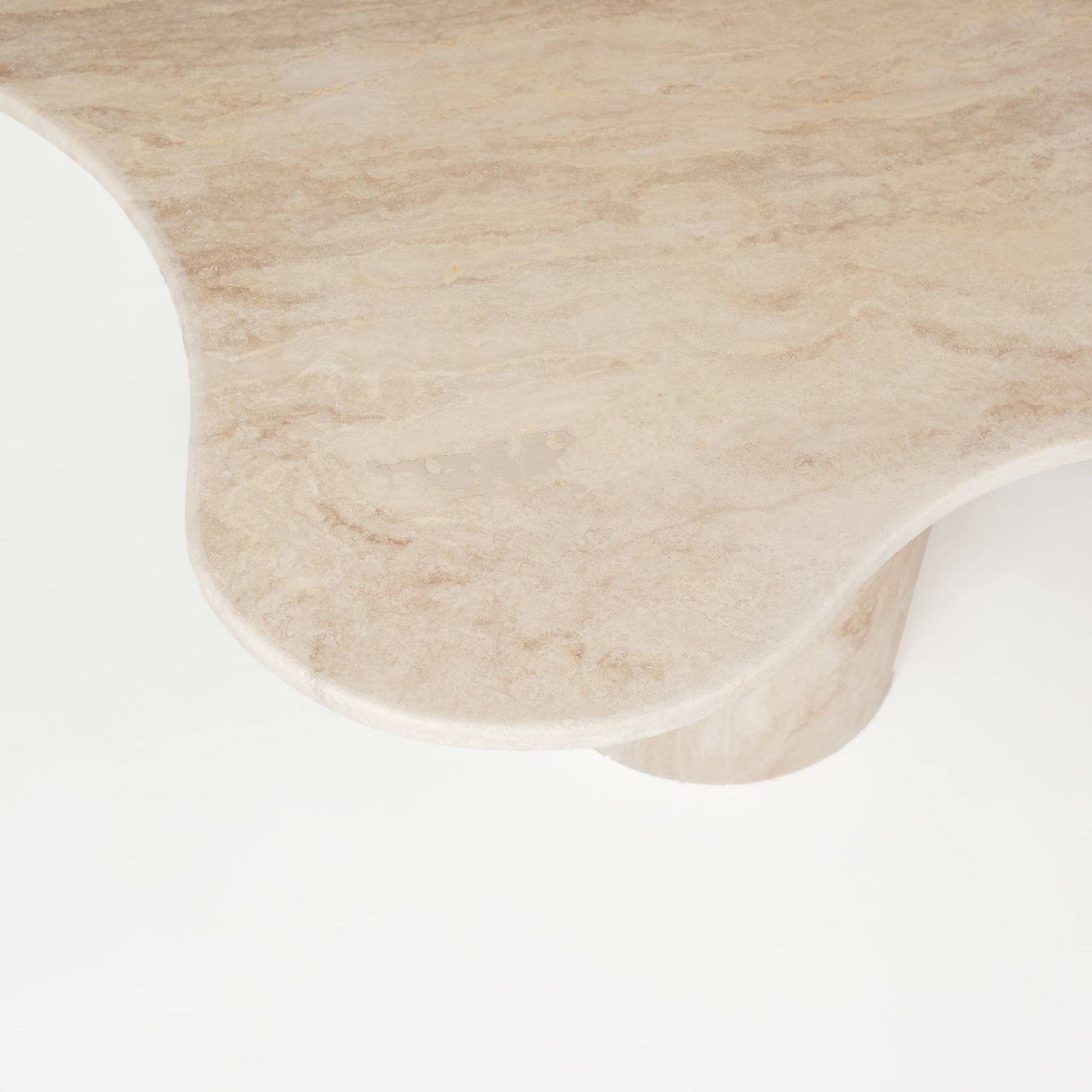 Detailaufnahme des geschwungenen Designs der Travertin-Tischplatte des Esstischs Organic, das die natürliche Struktur und die elegante Formgebung hervorhebt.