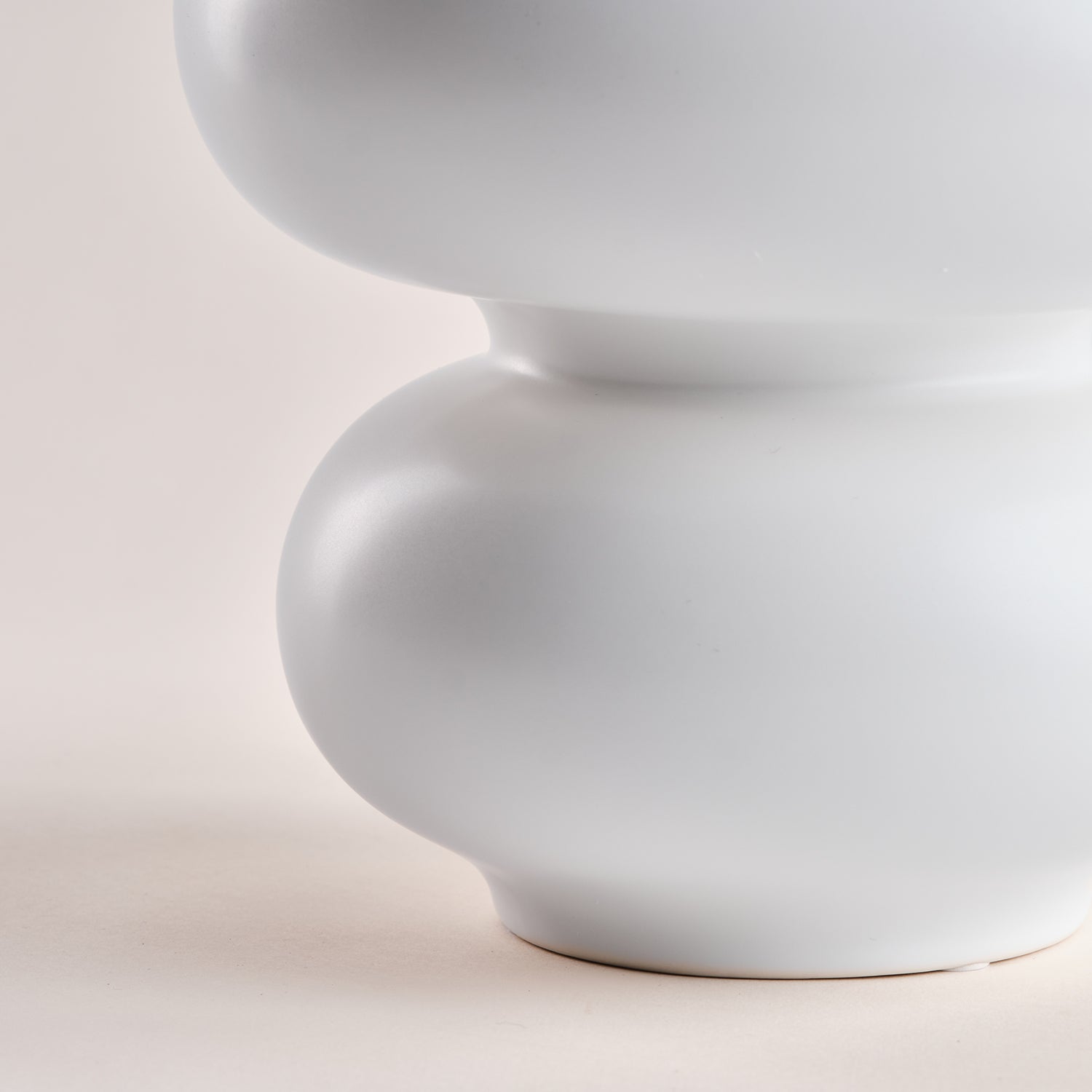Detailaufnahme einer weißen Porzellanvase namens "Bubble" aus der exklusiven Porzellanvasen-Kollektion. Die Vase besticht durch ihre weichen, organischen Rundformen und ihr minimalistisches Design, perfekt für stilvolle Wohnräume.