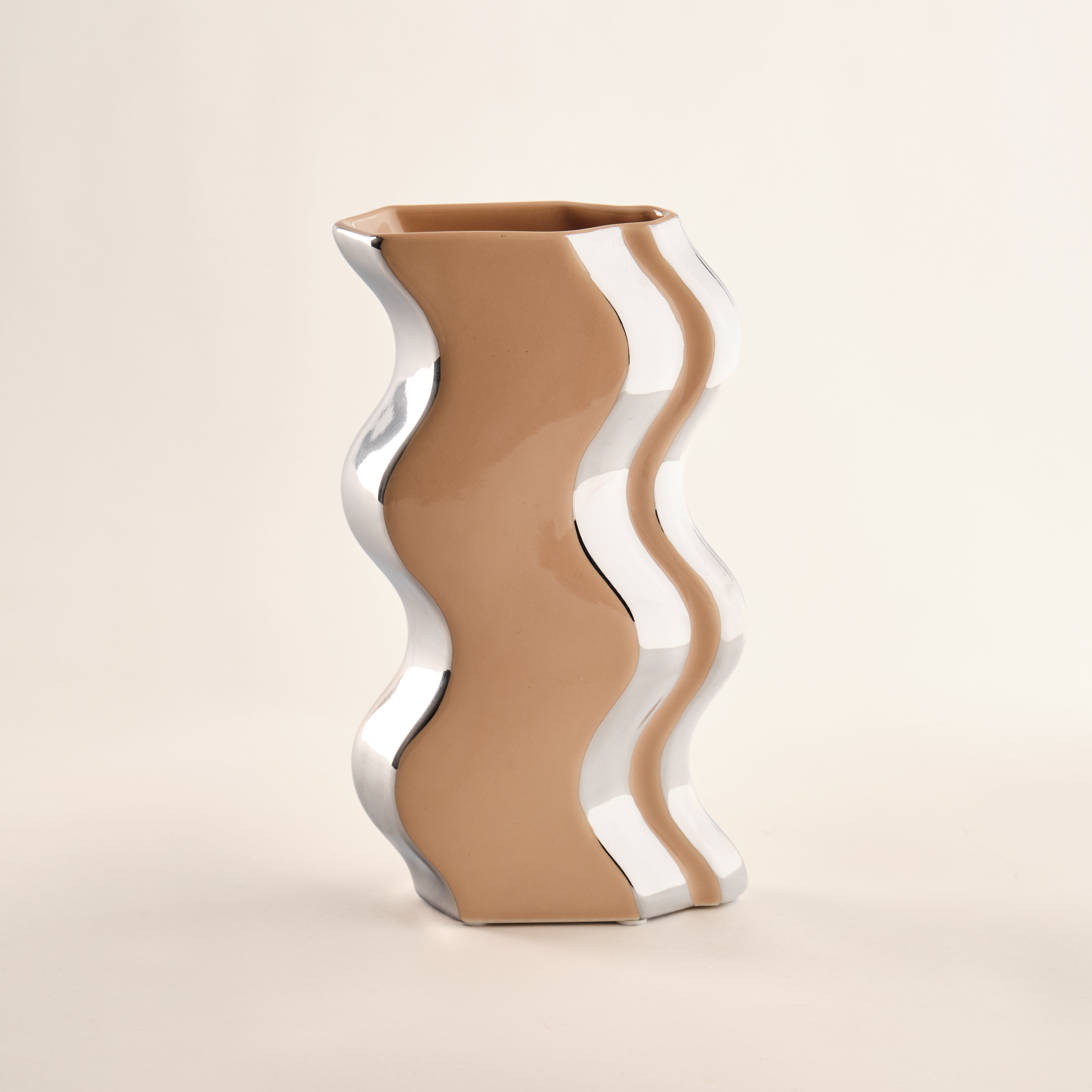 Die Porzellanvase "Curl" mit einer einzigartigen Kombination aus glänzendem Chrom und sanftem Beigeton. Die wellenartige Form verleiht der Vase eine moderne und elegante Ausstrahlung. Perfekt als stilvolles Deko-Objekt oder für kreative Blumenarrangements in jedem Raum.
