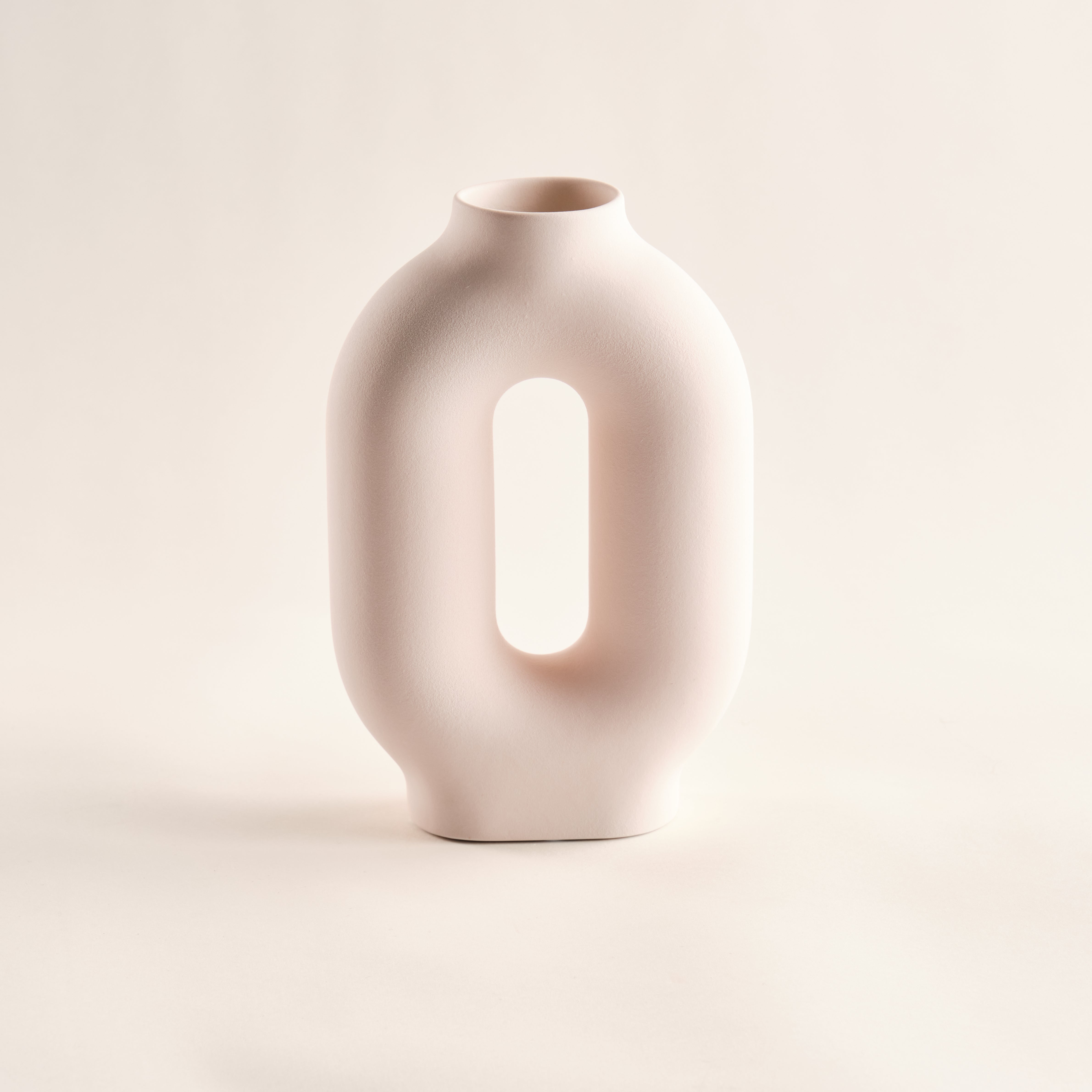 Minimalistische Porzellanvase "Donut" mit einzigartiger ovaler Öffnung und sanft-matter Oberfläche. Ideal für moderne Einrichtungskonzepte und stilvolle Wohnräume.