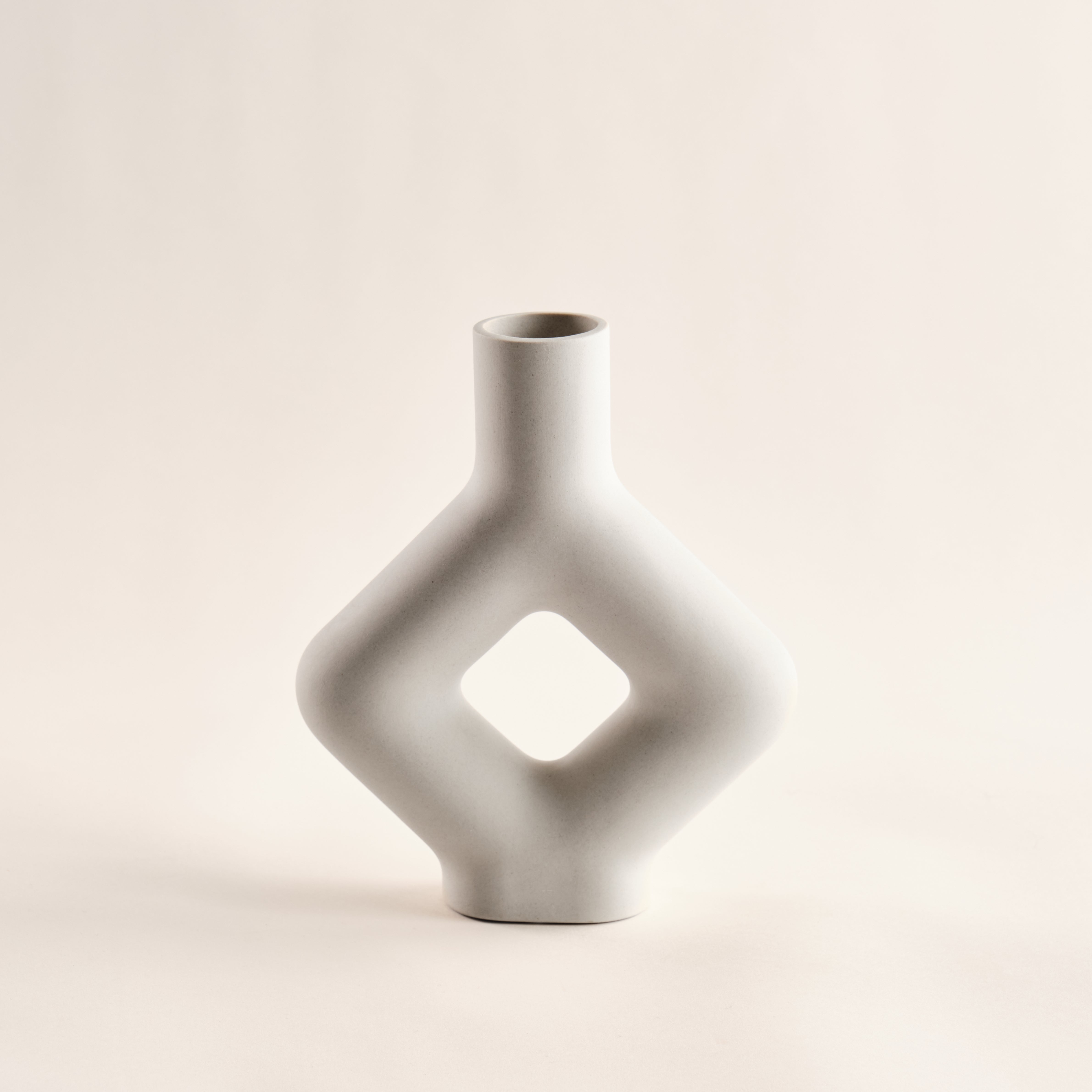 Porzellanvase "Karo" mit geometrischer Form und zentralem Rautenausschnitt in elegantem Weiß. Ideal für minimalistische und moderne Inneneinrichtungen.