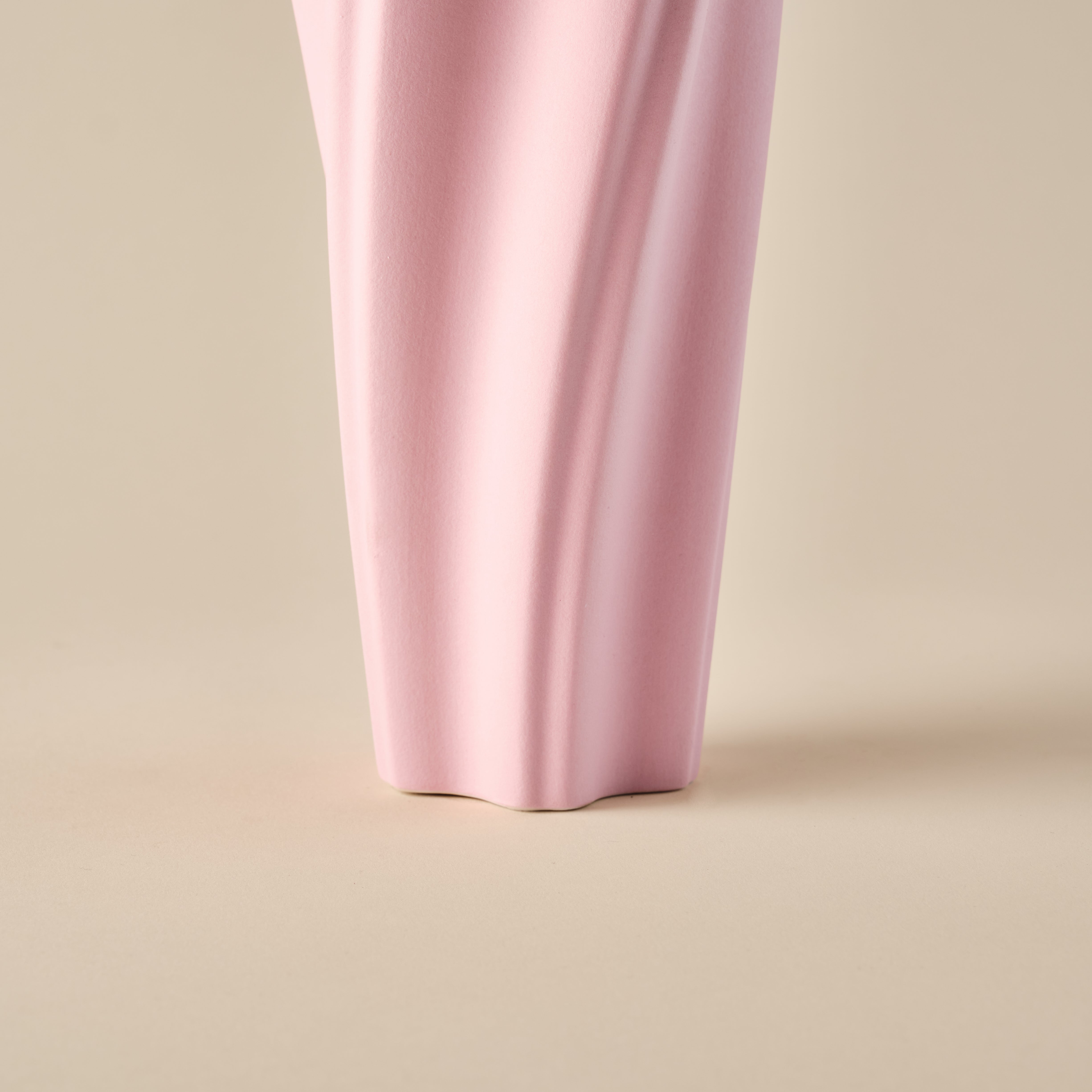 Detailaufnahme der unteren Partie der Porzellanvase "Wind" in Rosa. Die wellenförmige Struktur und der solide Standfuß verleihen der Vase ein elegantes und modernes Design. Ideal für zeitgemäße Wohnraumdekorationen.