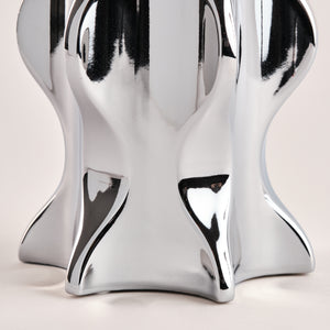 Detailansicht der Basis der Porzellanvase "Cactus" in glänzendem Chrom. Die geschwungenen und organischen Formen des Designs reflektieren das Licht und verleihen der Vase ein elegantes und zeitgemäßes Aussehen.