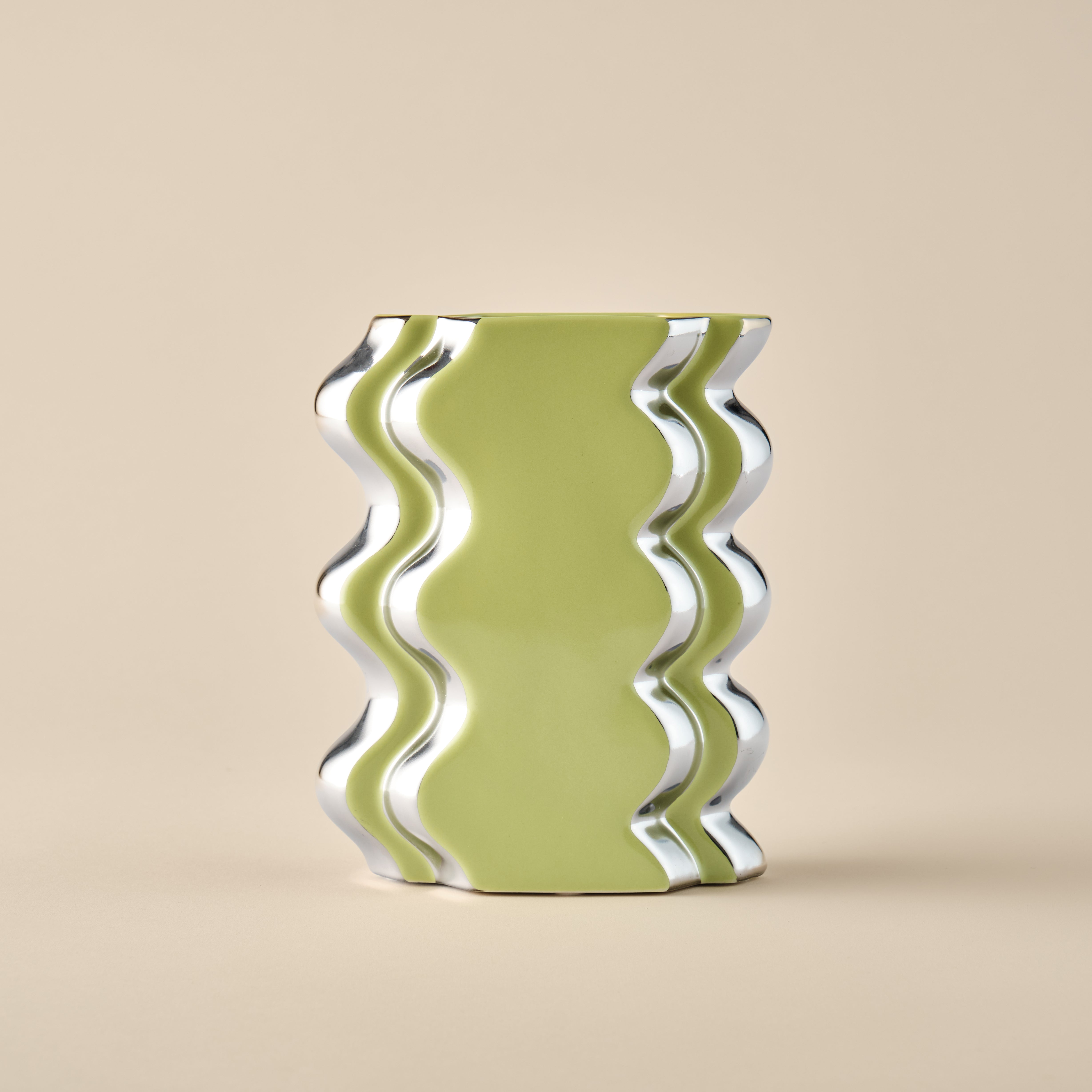 Die Porzellanvase "Double Curl" in frischem Limettengrün mit wellenförmigen Chromdetails. Ein einzigartiges, modernes Designstück für stilvolle Inneneinrichtung.