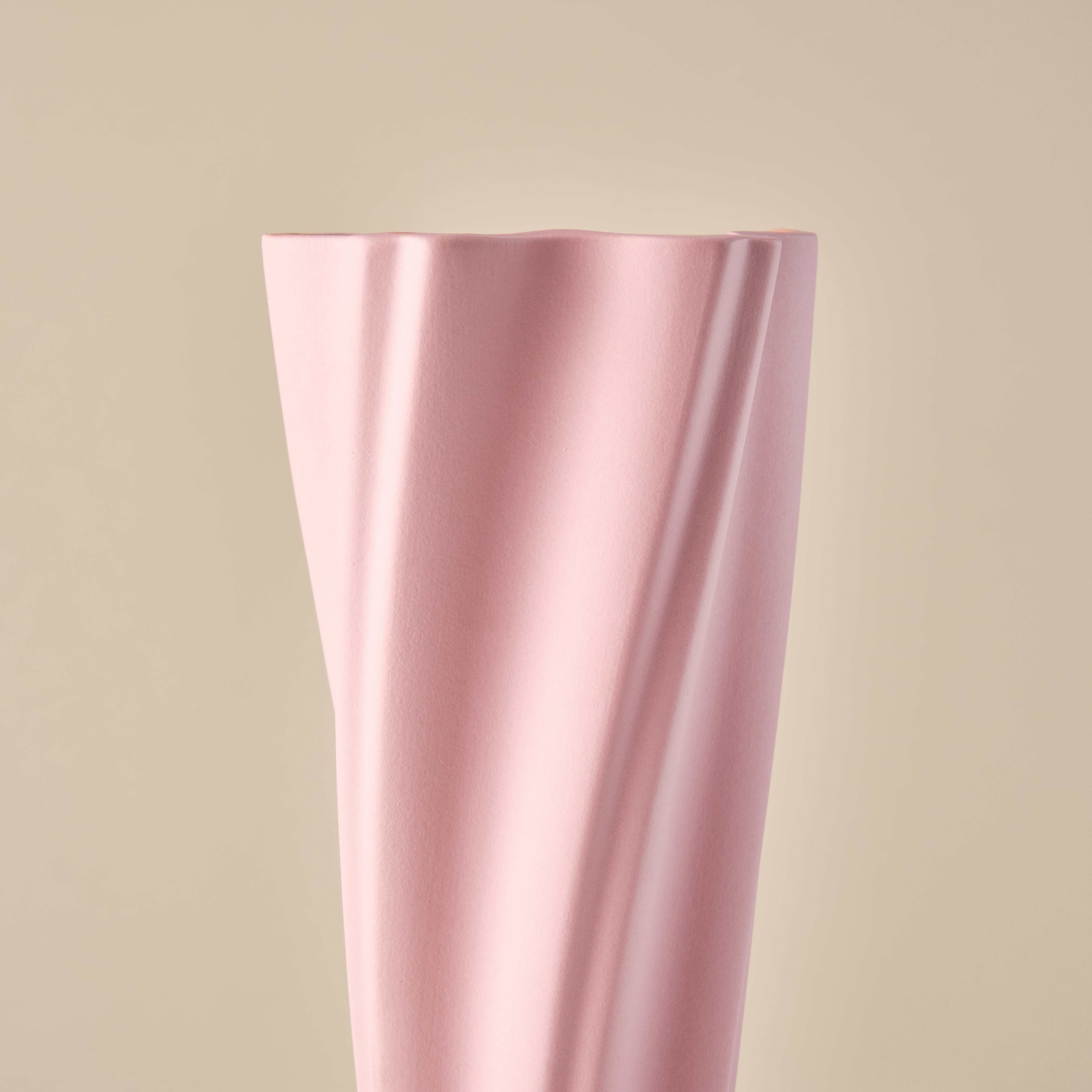 Nahaufnahme der Porzellanvase "Wind" in Rosa. Die wellenförmigen Linien der Vase betonen ihre elegante und moderne Ästhetik. Ideal für stilvolle Dekorationen oder Blumenarrangements.