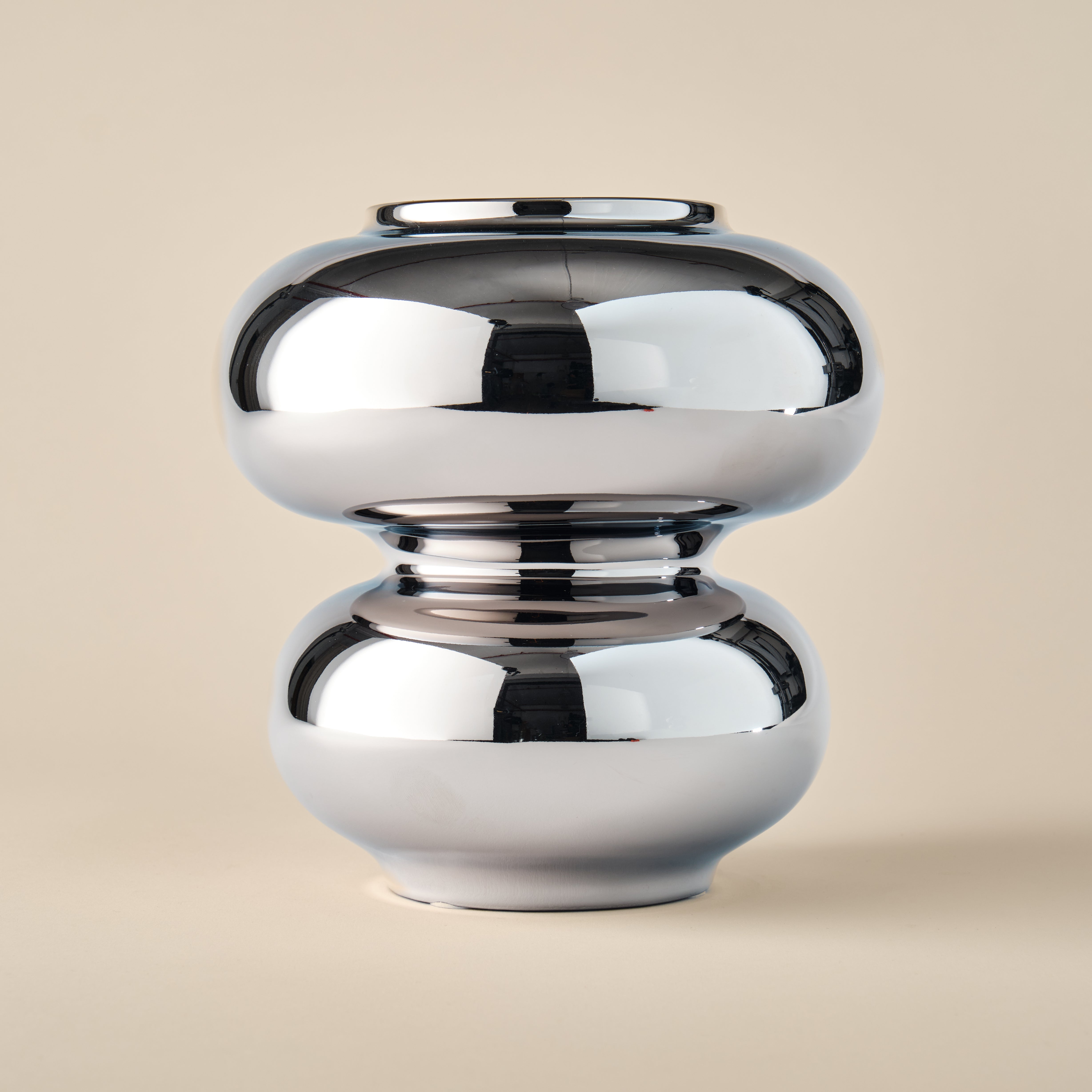 Porzellanvase aus der Kollektion "Bubble Chrom" mit glänzendem Chrom-Finish. Die Vase zeichnet sich durch ihre geschwungene, abgerundete Form und ihren spiegelnden Metallic-Effekt aus – ein Highlight für moderne Wohnräume.