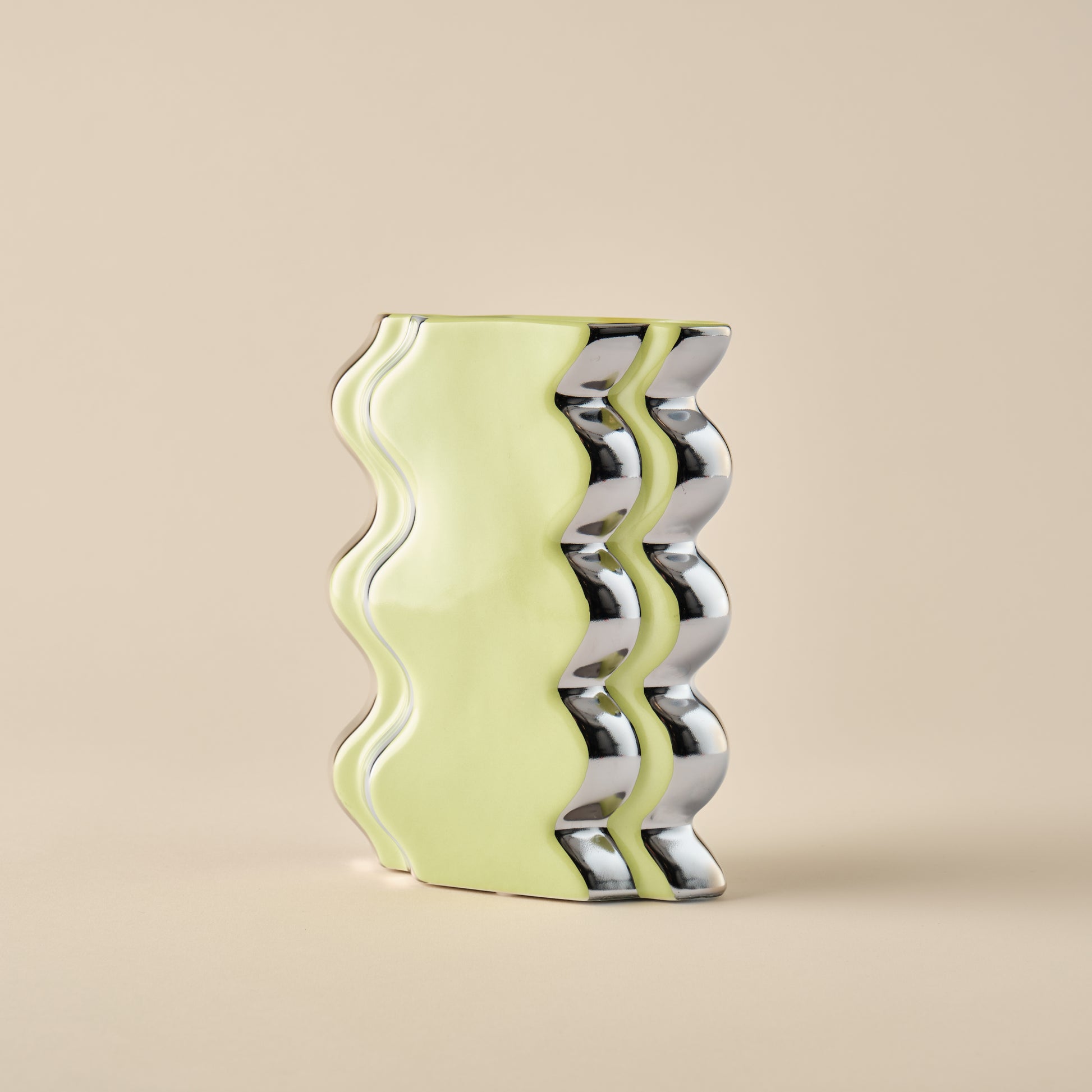 Detailaufnahme der Porzellanvase "Double Curl" in Limettengrün mit wellenförmigem Design und glänzenden Chromakzenten. Perfekt für stilvolle Dekoration.