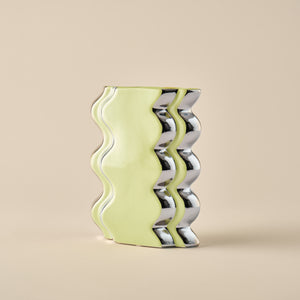 Detailaufnahme der Porzellanvase "Double Curl" in Limettengrün mit wellenförmigem Design und glänzenden Chromakzenten. Perfekt für stilvolle Dekoration.