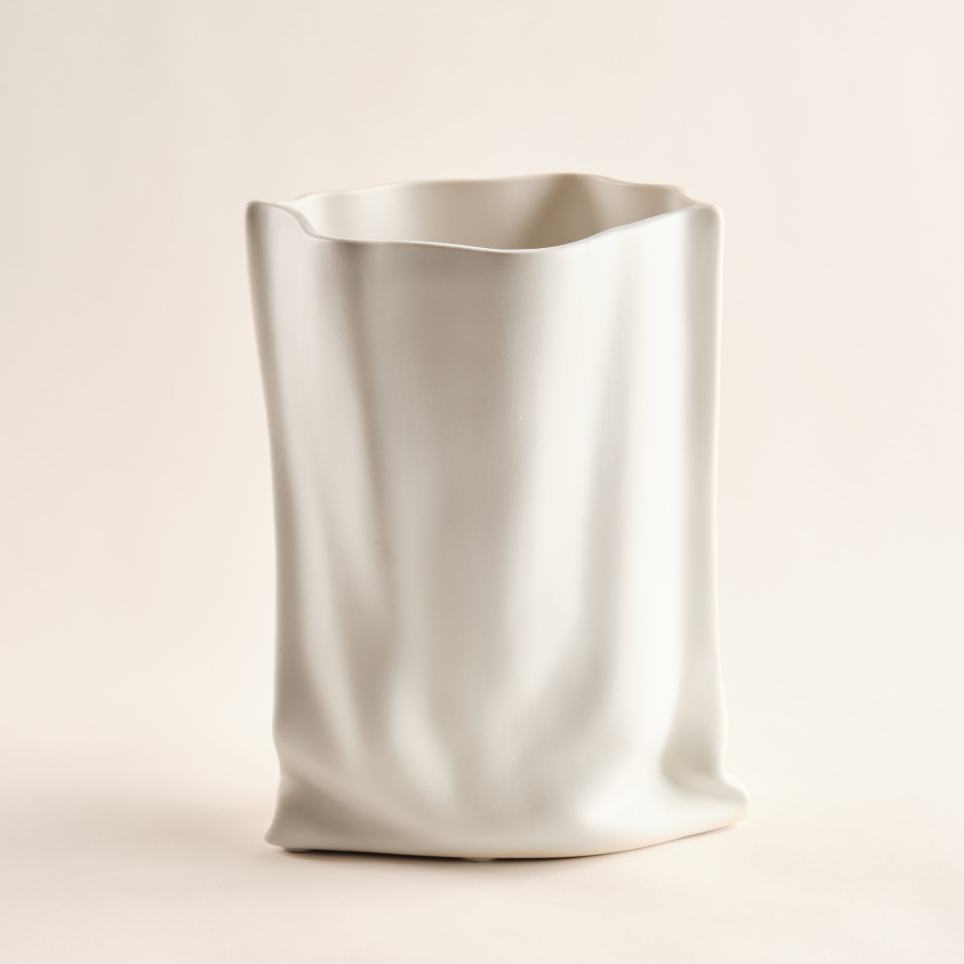 Porzellanvase "Paper Bag" mit geschwungenen, unregelmäßigen Linien, die an eine Papiertüte erinnern. Ein einzigartiges und modernes Designstück für stilvolle Wohnräume.