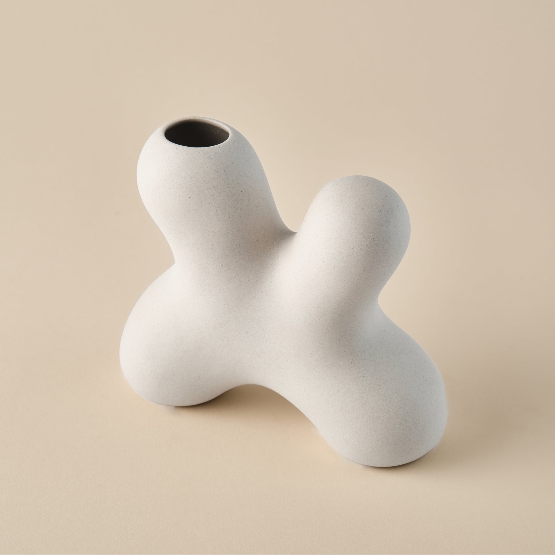 Detailaufnahme der Porzellanvase "Splash" in einer organischen, skulpturalen Form mit matter, cremefarbener Oberfläche. Ideal für moderne und minimalistische Innenräume.