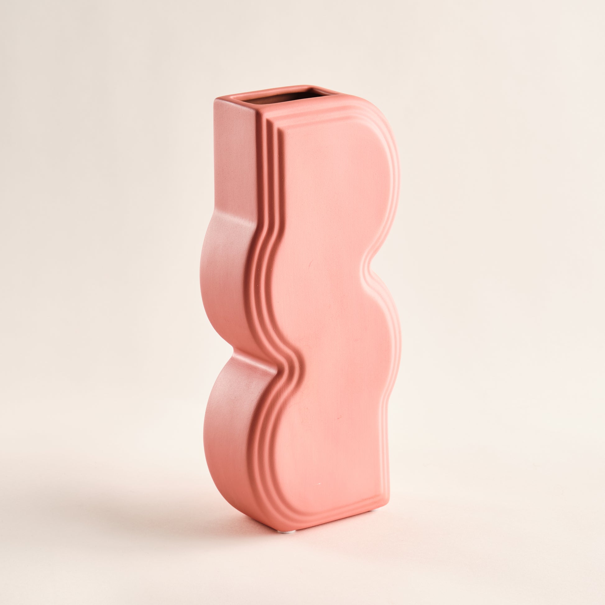 Stilvolle Porzellanvase "Whirl" in leuchtendem Korallrosa. Die geschwungene Form mit eleganten Reliefmustern verleiht dieser Vase ein modernes und auffälliges Design, ideal für zeitgenössische Wohnräume.