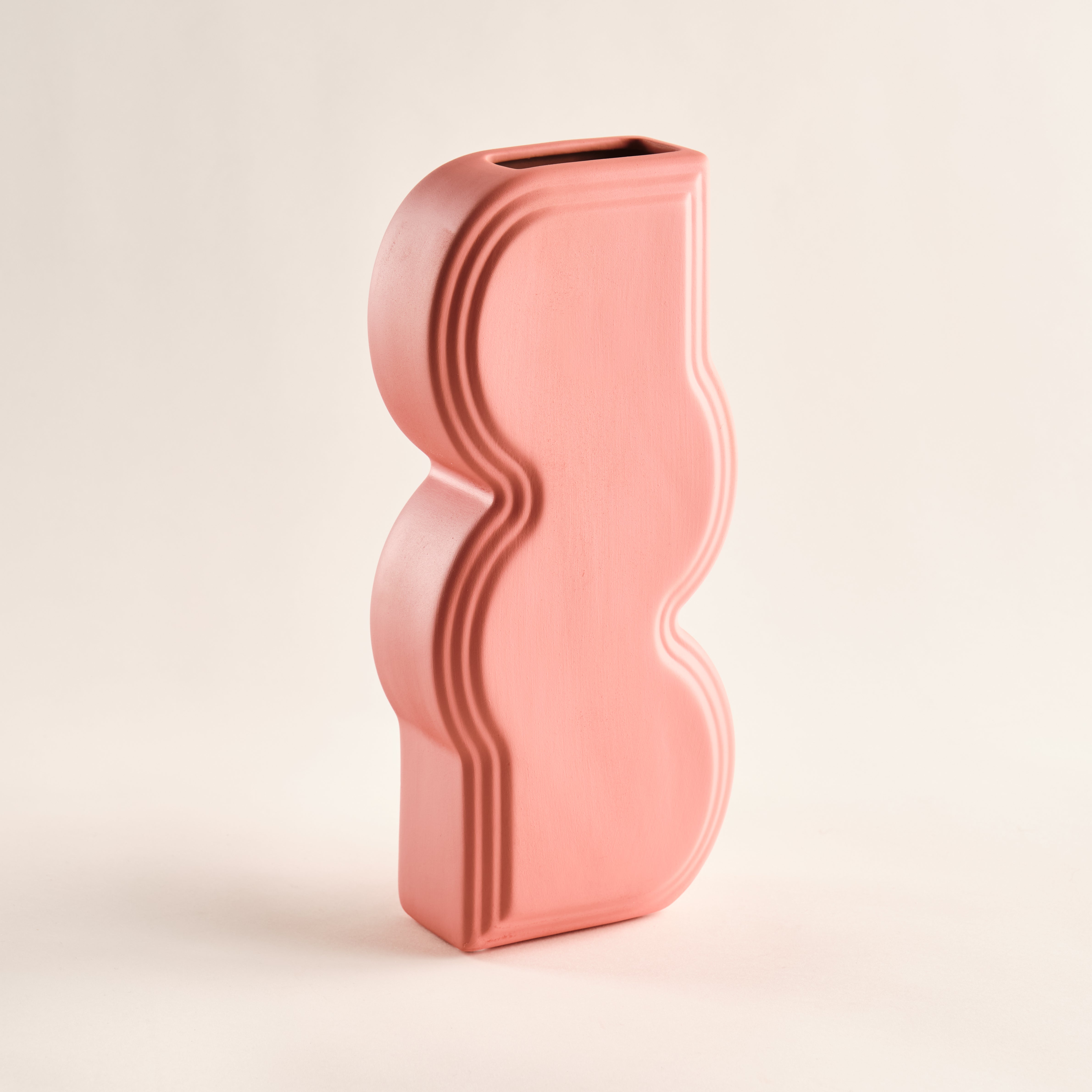 Porzellanvase "Whirl" in einem sanften Korallrosa. Die geschwungenen Linien und das minimalistische Design machen diese Vase zu einem eleganten Akzentstück für moderne Wohnräume. Perfekt für zeitlose Dekoration.