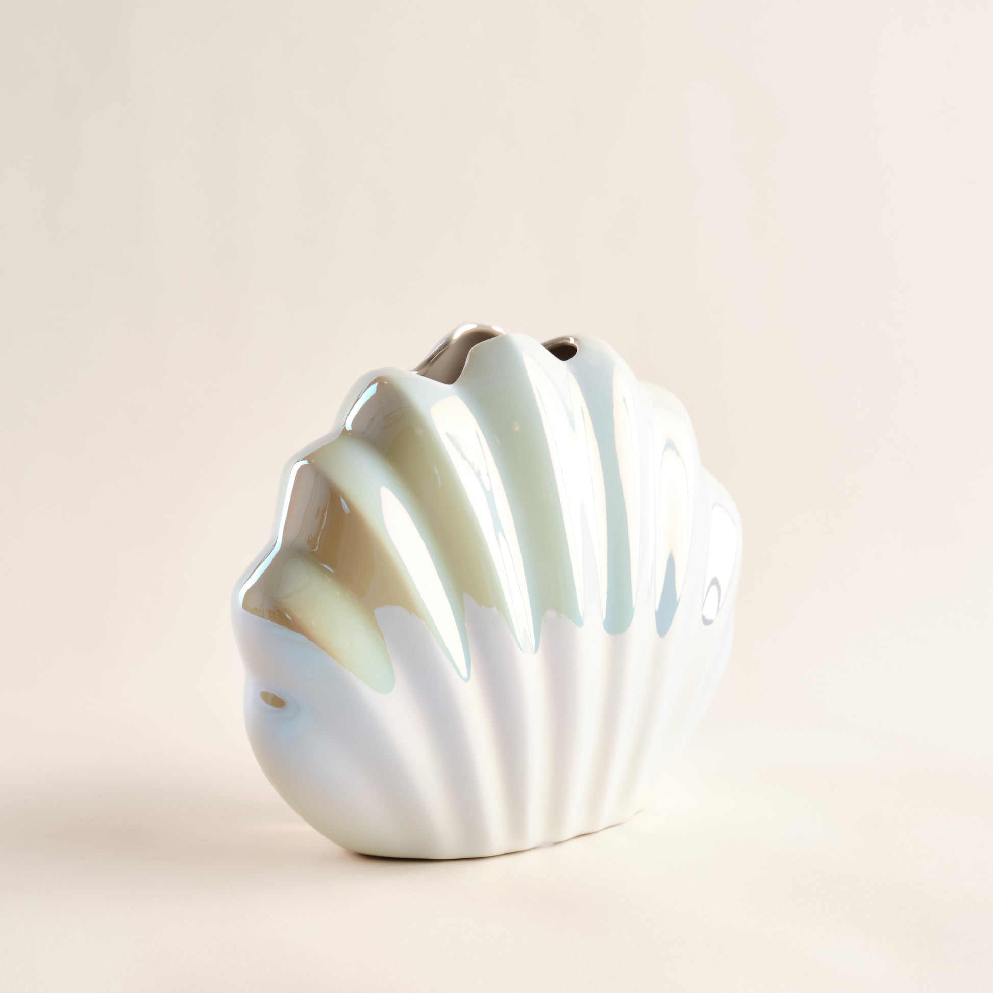Porzellanvase "Seashell Rainbow" in seitlicher Ansicht, inspiriert von einer Muschelform, mit glänzender Regenbogen-Glasur und geschwungenen Details, die maritime Eleganz verkörpern.