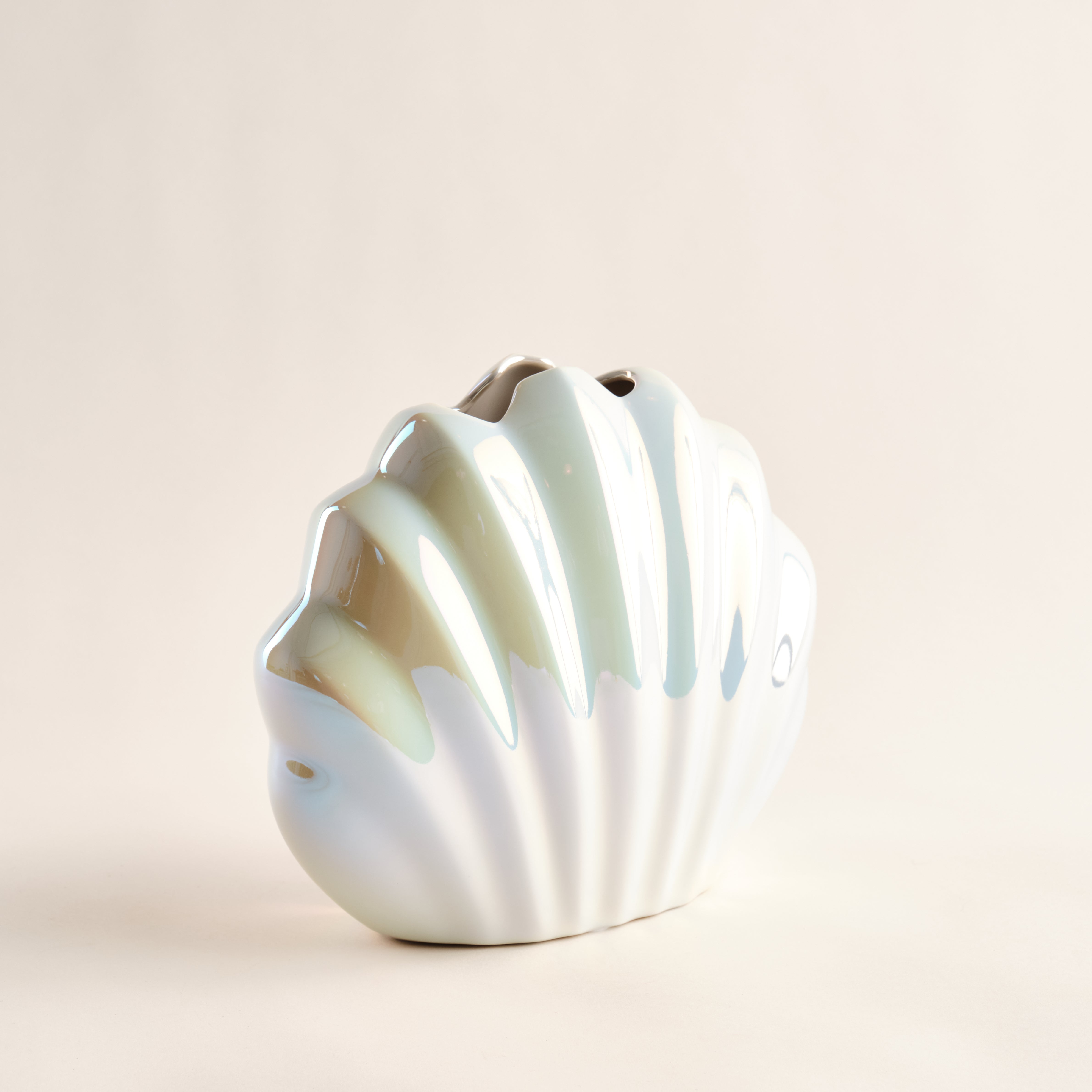 Porzellanvase "Seashell Rainbow" in seitlicher Ansicht, inspiriert von einer Muschelform, mit glänzender Regenbogen-Glasur und geschwungenen Details, die maritime Eleganz verkörpern.