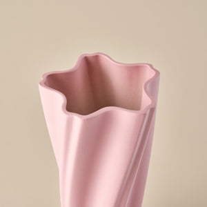 Detailaufnahme der Porzellanvase "Wind" in Rosa. Das wellenförmige Design der Öffnung unterstreicht die dynamische und moderne Gestaltung der Vase, ideal für ein zeitgemäßes Interieur oder als stilvolle Dekoration.