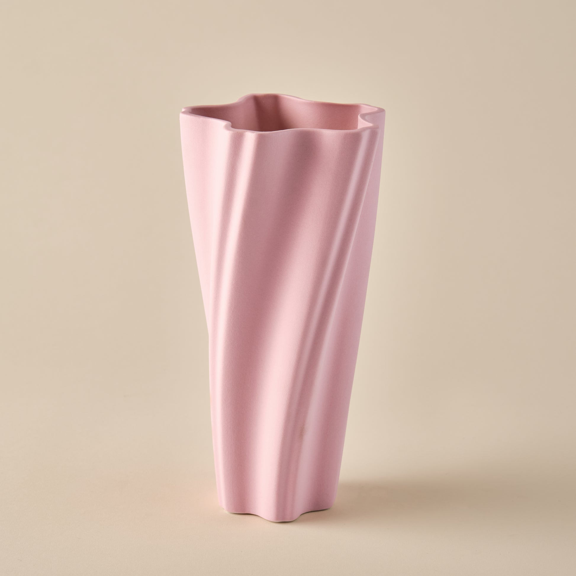 Porzellanvase "Wind" in sanftem Rosa mit einem dynamischen, gedrehten Design. Die fließenden Linien verleihen der Vase eine moderne und elegante Ästhetik, perfekt für stilvolle Wohnräume oder minimalistische Dekoration.