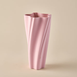 Porzellanvase "Wind" in sanftem Rosa mit einem dynamischen, gedrehten Design. Die fließenden Linien verleihen der Vase eine moderne und elegante Ästhetik, perfekt für stilvolle Wohnräume oder minimalistische Dekoration.